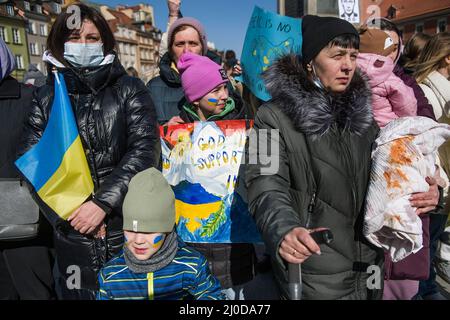 Warschau, Polen. 18. März 2022. Ukrainische Frauen und Kinder halten während des Protestes Plakate und ukrainische Flaggen. Der "Marsch der ukrainischen Mütter" fand in Warschau statt, der auch ein Protest gegen den Krieg und die Tötung ukrainischer Kinder war. Die Parolen des marsches waren: "Welt, helft unseren Kindern", "Stoppt den Krieg", "rettet Kinder der Ukraine" und "schließt den Himmel". An dem Protest nahmen vor allem ukrainische Mütter und ihre Kinder Teil, die vor dem Krieg in Polen Zuflucht fanden. Kredit: SOPA Images Limited/Alamy Live Nachrichten Stockfoto