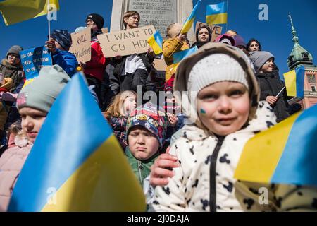 Warschau, Polen. 18. März 2022. Ukrainische Kinder halten Plakate und schwenken ukrainische Flaggen während des Protestes. Der "Marsch der ukrainischen Mütter" fand in Warschau statt, der auch ein Protest gegen den Krieg und die Tötung ukrainischer Kinder war. Die Parolen des marsches waren: "Welt, helft unseren Kindern", "Stoppt den Krieg", "rettet Kinder der Ukraine" und "schließt den Himmel". An dem Protest nahmen vor allem ukrainische Mütter und ihre Kinder Teil, die vor dem Krieg in Polen Zuflucht fanden. (Foto von Attila Husejnow/SOPA Images/Sipa USA) Quelle: SIPA USA/Alamy Live News Stockfoto