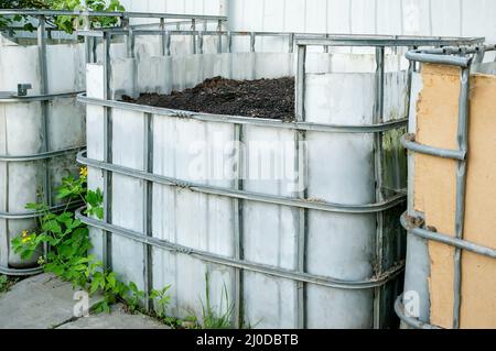 Gerät zur Kompost-Herstellung in einem öffentlichen Gemüsegarten. Müll wird für die Produktion von fruchtbarem Boden gesammelt Stockfoto