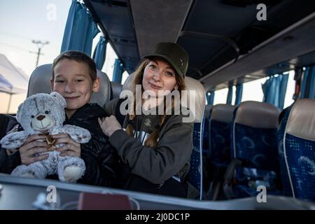 Vysne Nemecke, Slowakei. 18. März 2022. In Vysne Nemecke, an der slowakischen Grenze zur Ukraine, fahren Ira und ihr Sohn Sascha (11) in einem Bus, der sie zur Unterkunft in der Stadt Kosice bringen soll. Sie wollen von dort aus weiter zu Freunden in der slowakischen Stadt Trencin. Sasha und seine Mutter sind seit etwa zwei Wochen auf der Flucht. Sie kommen aus Zaporizhzhya im Süden der Ukraine. Dort befindet sich das größte Atomkraftwerk Europas, und aus Angst vor einem Angriff haben die beiden ihren Weg in die Slowakei gefunden. Quelle: Christoph Reichwein/dpa/Alamy Live News Stockfoto