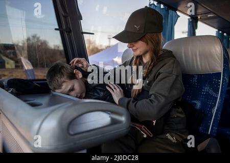 Vysne Nemecke, Slowakei. 18. März 2022. In Vysne Nemecke, an der slowakischen Grenze zur Ukraine, fahren Ira und ihr Sohn Sascha (11) in einem Bus, der sie zur Unterkunft in der Stadt Kosice bringen soll. Sie wollen von dort aus weiter zu Freunden in der slowakischen Stadt Trencin. Sasha und seine Mutter sind seit etwa zwei Wochen auf der Flucht. Sie kommen aus Zaporizhzhya im Süden der Ukraine. Dort befindet sich das größte Atomkraftwerk Europas, und aus Angst vor einem Angriff haben die beiden ihren Weg in die Slowakei gefunden. Quelle: Christoph Reichwein/dpa/Alamy Live News Stockfoto