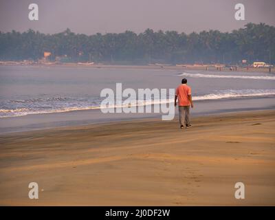 Sindhudurg, Indien - 20. Dezember 2021 : Unidentifizierter Mann, der einen Morgenspaziergang am Strand macht Stockfoto