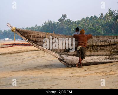 Malvan, Indien - 20. Dezember 2021 : Indische Fischer mit Fischerboot an der Küste. Stockfoto