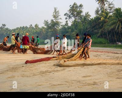 Malvan, Indien - 20. Dezember 2021 : Indische Fischer mit Fischernetz an der Küste. Stockfoto