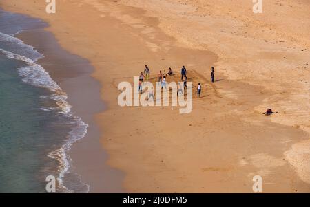 Sindhudurg, Indien - 21. Dezember 2021 : Unidentifizierte indische Jungs spielen Beachvolleyball am sauberen und sauberen Devgadh Strand. Stockfoto