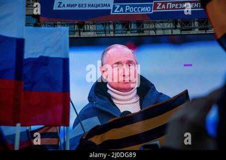 Moskau, Russland. 18.. März 2022 Übertragung von Wladimir Putins Rede auf der Großleinwand zum Konzert-Wahlkampf "für eine Welt ohne Nazismus! Für Russland! Für den Präsidenten!“, gewidmet am Tag der Wiedervereinigung der Krim mit Russland, in der großen Sportarena „Luzhniki“ in Moskau, Russland Quelle: Nikolay Vinokurov/Alamy Live News Stockfoto