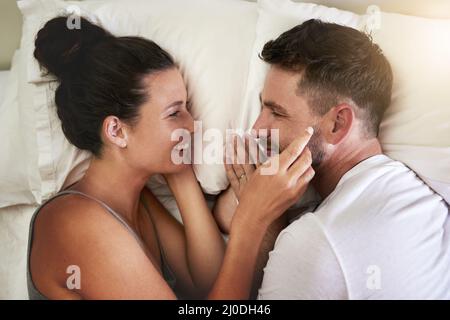Ich bin froh, dass ich neben dir aufwache. Eine kurze Aufnahme eines jungen, attraktiven Paares, das zu Hause im Bett liegt. Stockfoto