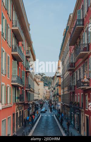 Nizza, Frankreich - 10. März 2022: Blick auf eine typische Straße mit traditionellen bunten Gebäuden in Nizza, einem berühmten Touristenziel auf den Franzosen Stockfoto