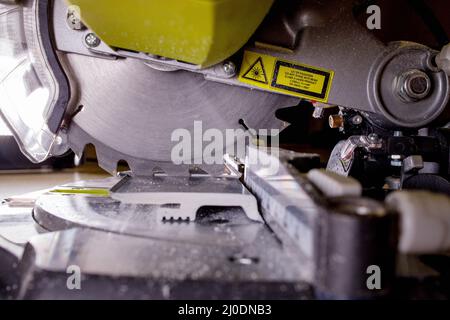 Arbeiter schneidet die Schonplatte an der Kreissäge vor dem Einbau. Stockfoto