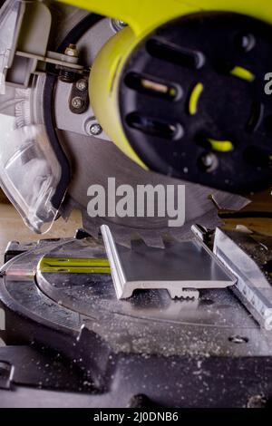 Arbeiter schneidet die Schonplatte an der Kreissäge vor dem Einbau. Stockfoto