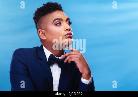 Verloren in einem Reich der Gedanken. Ausgeschnittene Aufnahme eines jungen Geschäftsmanns, der vor blauem Hintergrund posiert. Stockfoto