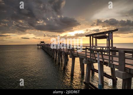 Rosa und lila Sonnenuntergang über dem Naples Pier an der Golfküste von Naples, Florida Stockfoto