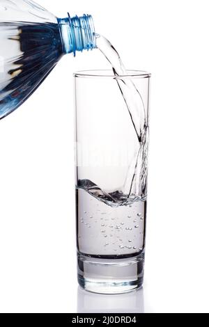 Wasser aus der Flasche in Glas gießen Stockfoto