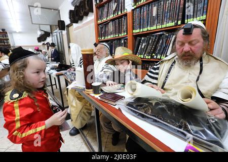 Jerusalem. 18. März 2022. Ultra-orthodoxe Juden lasen das Buch Esther während des jüdischen Feiertags von Purim in einer Synagoge in Jerusalem am 18. März 2022. Purim ist ein jüdischer Feiertag, der an die Befreiung des jüdischen Volkes von Hamans Verschwörung während der Herrschaft des alten persischen Reiches gemäß dem biblischen Buch Esther erinnert. Quelle: Gil Cohen Magen/Xinhua/Alamy Live News Stockfoto