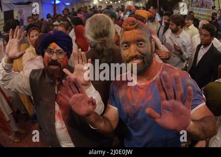 Lahore, Punjab, Pakistan. 18. März 2022. Hindu-Gemeinschaft und verschiedene Lebenslagen feiern Holi, schmieren sich die Gesichter mit Gulal, einem farbigen Pulver, das bei den Holi-Festlichkeiten im Holi Krishna Mandir in Lahore verwendet wird. Holi markiert den Beginn des Frühlings und den Triumph des Guten über das Böse. Zu den Feierlichkeiten gehört das Werfen von farbenfroher Farbe, Pulver und Wasser auf die Menschen. Holi beobachtete in Pakistan am Ende der Wintersaison auf dem letzten Vollmond des Mondmonats. Kredit: ZUMA Press, Inc./Alamy Live Nachrichten Stockfoto