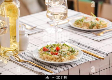 Teller Pasta mit Rucola und Käse auf dem Tisch Stockfoto