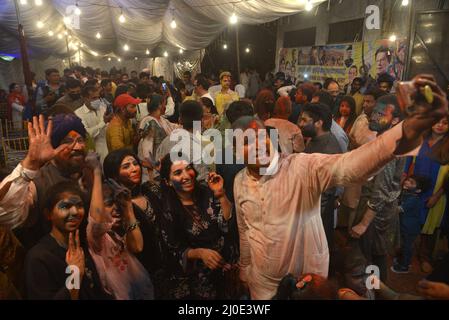 Lahore, Punjab, Pakistan. 18. März 2022. Hindu-Gemeinschaft und verschiedene Lebenslagen feiern Holi, schmieren sich die Gesichter mit Gulal, einem farbigen Pulver, das bei den Holi-Festlichkeiten im Holi Krishna Mandir in Lahore verwendet wird. Holi markiert den Beginn des Frühlings und den Triumph des Guten über das Böse. Zu den Feierlichkeiten gehört das Werfen von farbenfroher Farbe, Pulver und Wasser auf die Menschen. Holi beobachtete in Pakistan am Ende der Wintersaison auf dem letzten Vollmond des Mondmonats. Kredit: ZUMA Press, Inc./Alamy Live Nachrichten Stockfoto