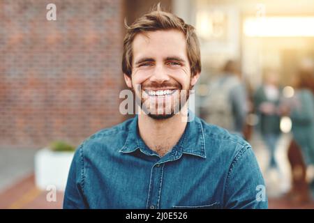 Ich bin bereit für meine Zukunft. Porträt eines glücklichen jungen Mannes, der draußen auf dem Campus steht. Stockfoto