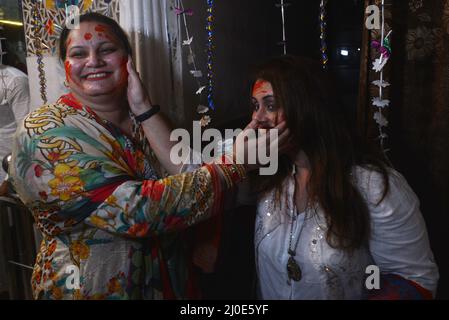 Lahore, Punjab, Pakistan. 18. März 2022. Hindu-Gemeinschaft und verschiedene Lebenslagen feiern Holi, schmieren sich die Gesichter mit Gulal, einem farbigen Pulver, das bei den Holi-Festlichkeiten im Holi Krishna Mandir in Lahore verwendet wird. Holi markiert den Beginn des Frühlings und den Triumph des Guten über das Böse. Zu den Feierlichkeiten gehört das Werfen von farbenfroher Farbe, Pulver und Wasser auf die Menschen. Holi beobachtete in Pakistan am Ende der Wintersaison auf dem letzten Vollmond des Mondmonats. Kredit: ZUMA Press, Inc./Alamy Live Nachrichten Stockfoto