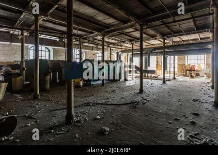 Alte verlassene Fabrik mit Überresten von Ausrüstung. Stockfoto