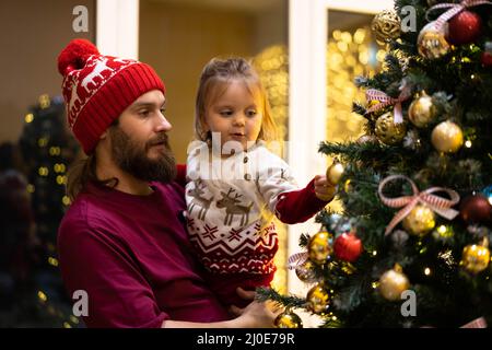 Glückliche Familie Austausch weihnachtsgeschenke in dekorierten Wohnzimmer mit Weihnachtsbaum . Glücklich liebenden Vater, Sohn und Weihnachtsbaum. Hochwertige Fotos. Stockfoto