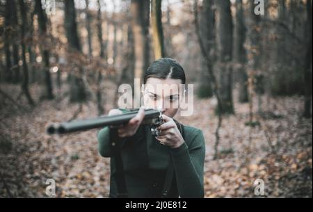 Hunter Frau mit Schrotflinte auf der Jagd. Jagd im Wald. Porträt der Frau Hunter. Jagdsaison geschlossen und geöffnet. Herbstjagd. Jagd. Stockfoto