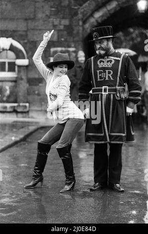 Beefeater Rory Crozier blickt ungläubig fort, als die Disco-Tänzerin Lucia Catti (18) bei einem Besuch im Tower of London auf Herz und Nieren geht. 8.. Dezember 1978. Stockfoto