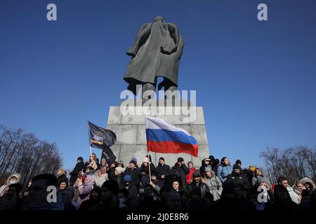 Moskau, Russland. 18. März 2022. 18. März 2022, Russland, Moskau: Am Rande eines Konzerts zum achten Jahrestag der Annexion der Halbinsel des Schwarzen Meeres auf der Krim am 18. März 2014 halten die Menschen Flaggen fest. Quelle: dpa picture Alliance/Alamy Live News Stockfoto