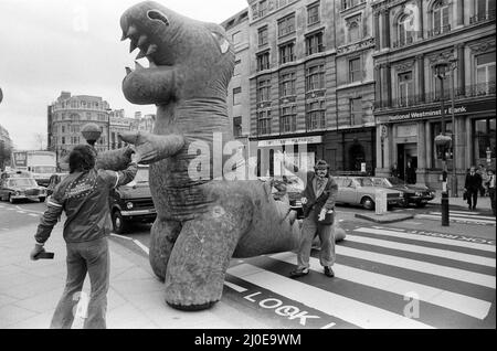 Auf dem Londoner Trafalgar Square kämpfen sich zwei Dinosaurier, die so hoch wie ein Doppeldeckerbus sind. Die Veranstaltung soll die Boys and Girls Exhibition bekannt geben, die am 10.. märz im Alexandra Palace eröffnet wird. Die riesigen lebensgroßen Monster kämpfen im tödlichen Kampf auf der Ausstellung. 6.. März 1979. Stockfoto