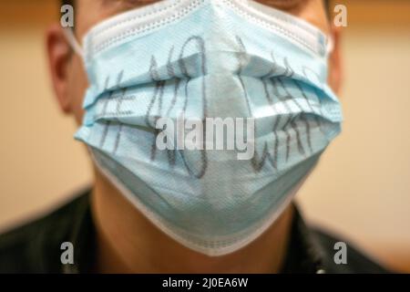 Russischer stiller Protestler ohne Kriegsbotschaft auf Covid19-Maske. Das russische Volk protestiert gegen den Krieg gegen die Ukraine. Stiller Protest durch russisches Konzept. Stockfoto