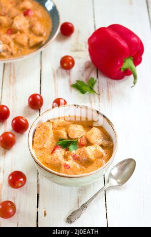 Chicken Eintopf mit Paprika in eine Schüssel geben. Stockfoto