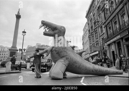 Auf dem Londoner Trafalgar Square kämpfen sich zwei Dinosaurier, die so hoch wie ein Doppeldeckerbus sind. Die Veranstaltung soll die Boys and Girls Exhibition bekannt geben, die am 10.. märz im Alexandra Palace eröffnet wird. Die riesigen lebensgroßen Monster kämpfen im tödlichen Kampf auf der Ausstellung. 6.. März 1979. Stockfoto