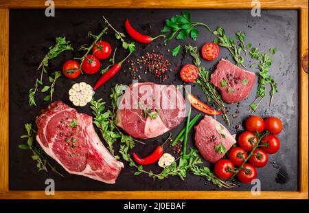 Rohes Fleisch Steaks auf einem dunklen Hintergrund bereit zu rösten Stockfoto