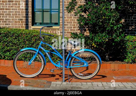 Blaues Fahrrad, an Schild gekettet Stockfoto