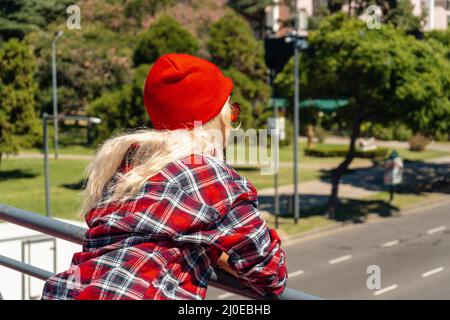 Eine wunderschöne, städtische Latina-Frau, die sich auf einem Brückengeländer stützt Stockfoto