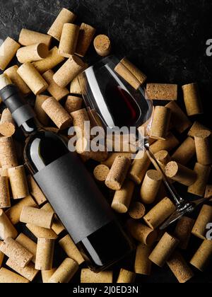 Eine Flasche Wein, ein Glas liegt auf Weinkorken. Nahaufnahme. Originalkomposition. Feiertag, Geburtstag, Jubiläum, romantischer Abend, Weinprobe. Banner, A Stockfoto
