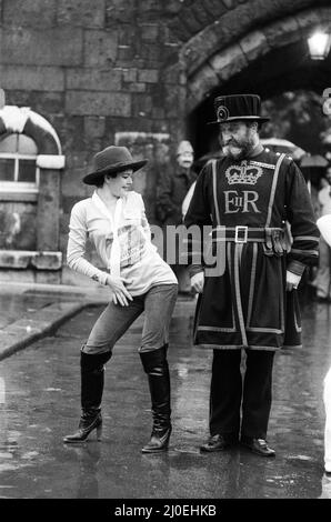 Beefeater Rory Crozier blickt ungläubig fort, als die Disco-Tänzerin Lucia Catti (18) bei einem Besuch im Tower of London auf Herz und Nieren geht. 8.. Dezember 1978. Stockfoto