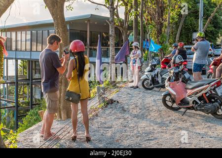 Die Menschen halten an, um Fotos von der Küstenstraße südlich von Karon in Phuket, Thailand, zu machen Stockfoto