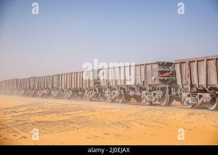 Güterwagen des längsten Zuges der Welt durchqueren die Wüste in der Region Adrar, Mauretanien Stockfoto