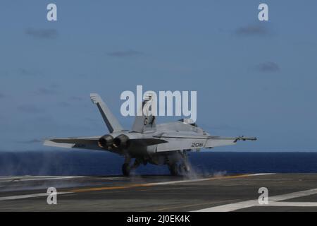 PHILIPPINISCHE SEE (17. März 2022) eine F/A-18E Super Hornet, die den "Tophoattern" des Strike Fighter Squadron (VFA) 14 zugewiesen wurde, startet vom Flugdeck des Nimitz-Klasse-Flugzeugträgers USS Abraham Lincoln (CVN 72). Die Abraham Lincoln Strike Group befindet sich im geplanten Einsatzgebiet der US-Flotte für 7., um die Interoperabilität durch Allianzen und Partnerschaften zu verbessern und gleichzeitig als reaktionsfähige Truppe zur Unterstützung einer freien und offenen Region im Indo-Pazifik-Raum zu dienen. (USA Navy Foto von Mass Communication Specialist Seaman Apprentice Julia Brockman) Stockfoto