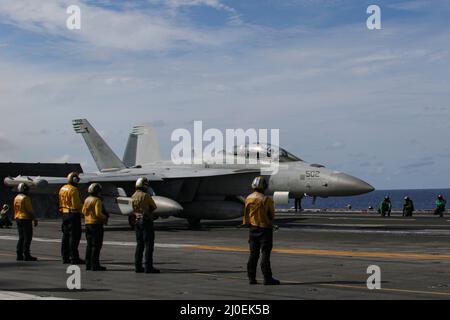 PHILIPPINISCHES MEER (17. März 2022) ein EA-18G Growler, der den 'Wizards' des Electronic Attack Squadron (VAQ) 133 zugewiesen wurde, bereitet sich auf den Start auf dem Flugdeck des Nimitz-Klasse-Flugzeugträgers USS Abraham Lincoln (CVN 72) vor. Die Abraham Lincoln Strike Group befindet sich im geplanten Einsatzgebiet der US-Flotte für 7., um die Interoperabilität durch Allianzen und Partnerschaften zu verbessern und gleichzeitig als reaktionsfähige Truppe zur Unterstützung einer freien und offenen Region im Indo-Pazifik-Raum zu dienen. (USA Navy Foto von Mass Communication Specialist Seaman Apprentice Julia Brockman) Stockfoto