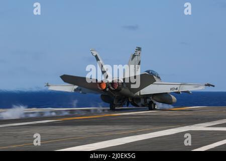 PHILIPPINISCHE SEE (17. März 2022) eine F/A-18F Super Hornet, die den 'Black Aces' des Strike Fighter Squadron (VFA) 41 zugewiesen wurde, startet vom Flugdeck des Nimitz-Klasse-Flugzeugträgers USS Abraham Lincoln (CVN 72). Die Abraham Lincoln Strike Group befindet sich im geplanten Einsatzgebiet der US-Flotte für 7., um die Interoperabilität durch Allianzen und Partnerschaften zu verbessern und gleichzeitig als reaktionsfähige Truppe zur Unterstützung einer freien und offenen Region im Indo-Pazifik-Raum zu dienen. (USA Navy Foto von Mass Communication Specialist Seaman Apprentice Julia Brockman) Stockfoto