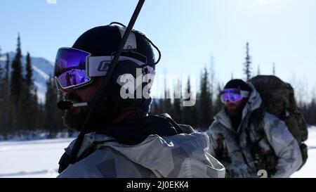 Ein Sondereinsatzkommaniger, der 10. Special Forces Group (Airborne) zugewiesen wurde, kommuniziert während der Übung ARCTIC EDGE 2022 in Wiseman, Alaska, 14. März 2022 mit einfliegenden Flugzeugen. AE22 ist eine alle zwei Jahre stattfindende Multi-Service-Übung, die den Teilnehmern realistische und effektive Schulungen an den wichtigsten Schulungsorten bietet, die vom 28. Februar bis zum 17. März in ganz Alaska verfügbar sind. (USA Foto der Armee von Staff Sgt. Anthony Bryant) Stockfoto