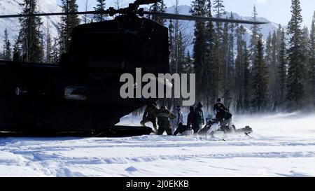 Green Berets mit 10. Special Forces Group (Airborne) laden ein Schneemobil in einen MH-47 Chinook Hubschrauber mit 160. Special Operations Aviation Regiment (Airborne) während der Übung ARCTIC EDGE 2022 in Wiseman, Alaska, 14. März 2022. AE22 ist eine alle zwei Jahre stattfindende Multi-Service-Übung, die den Teilnehmern realistische und effektive Schulungen an den wichtigsten Schulungsorten bietet, die vom 28. Februar bis zum 17. März in ganz Alaska verfügbar sind. (USA Foto der Armee von Staff Sgt. Anthony Bryant) Stockfoto