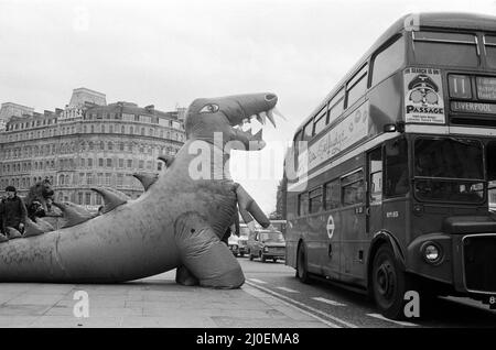 Auf dem Londoner Trafalgar Square kämpfen sich zwei Dinosaurier, die so hoch wie ein Doppeldeckerbus sind. Die Veranstaltung soll die Boys and Girls Exhibition bekannt geben, die am 10.. märz im Alexandra Palace eröffnet wird. Die riesigen lebensgroßen Monster kämpfen im tödlichen Kampf auf der Ausstellung. 6.. März 1979. Stockfoto