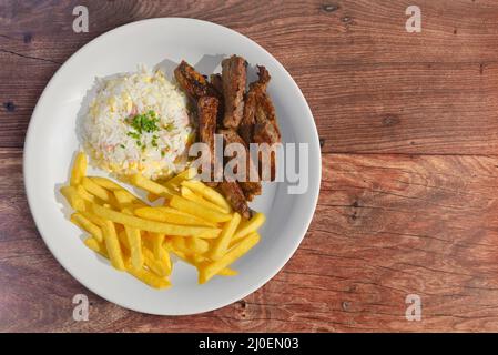 Steak in Scheiben mit Reis und Pommes frites Stockfoto