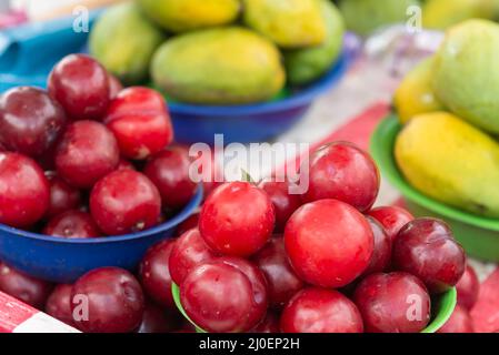 Pflaumen und Mangos stapelten sich auf dem Straßenmarkt Stockfoto