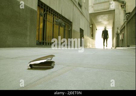 Low Angle View eines Geschäftsmannes zu Fuß, die seine Brieftasche gefallen ist. Stockfoto