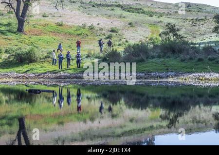 Eine Gruppe von Wanderern, die die Natur genießen und die schönen Reflexionen im Wasser in der Landschaft Nordkaliforniens betrachten. Stockfoto