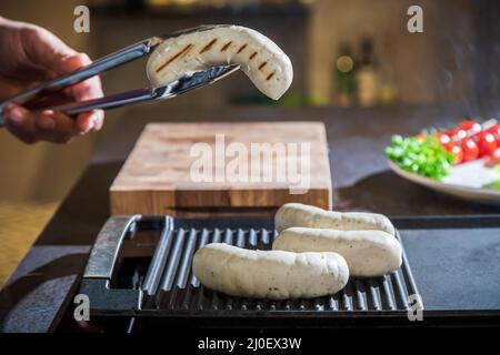 Ein Koch verwandelt die Zange des Hähnchens in ein gegrilltes Stockfoto